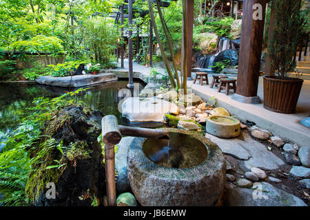 A tsukubai overlooking a fish pond at the Japanese traditional inn, or Ryokan, called Iwanoyu at Seni Onsen in Nagano, Japan Stock Photo