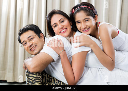 3 People At Home Daughter Family Father Girl Mother Smiling Sofa Teenager Stock Photo