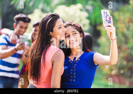 2 Indian College Girls Friend Taking Selfie Phone In Park Stock Photo
