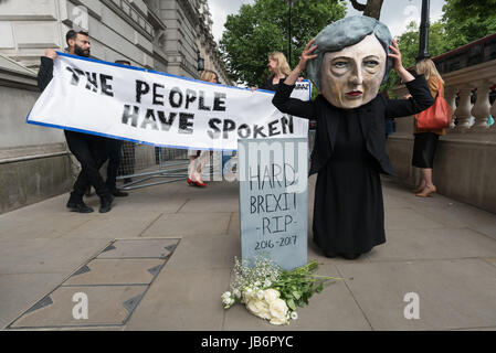 London, UK. 9th June 2017. After election results showed that no party had a majority, protesters came to Westminster to demand that Theresa May resign. She is intending to stay on and try and govern, relying on votes from the DUP party, linked to loyalist paramilitaries. Avaaz brought a person with a large caricature head of Theresa May to Downing St to pose in front of a banner 'The People Have Spoken' and lay white roses in front of a gravestone with the message 'Hard Brexist R.I.P 2016-2017'. Credit: ZUMA Press, Inc./Alamy Live News Stock Photo