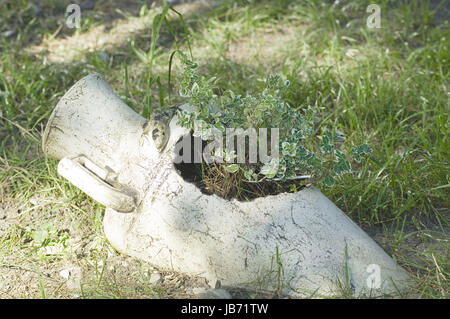 Antique jug with flowers on green grass Stock Photo