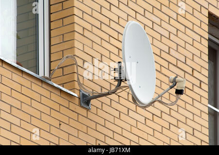 Antenna on wall near the window. Brick wall Stock Photo