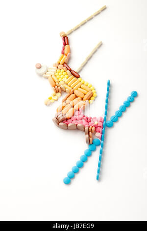 Doping pills and drugs in the shape of a winter jumping skier. Stock Photo