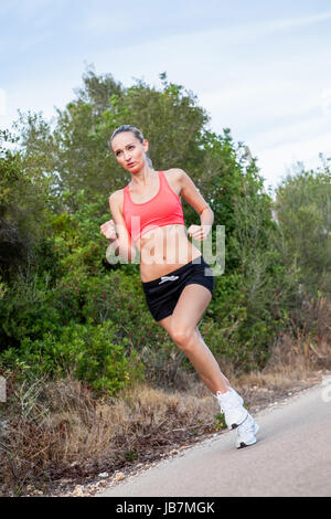 junge attraktive sportliche frau beim laufen joggen im freien sommer freizeit sport gesundheit bewegung Stock Photo