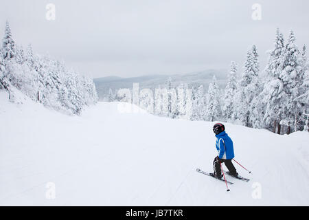 Mont-Tremblant, Canada - February 9, 2014: A boy is skiing down an easy slope at Mont-Tremblant. Mont-Tremblant Ski Resort is acknowledged by most industry experts as being the best ski resort in Eastern North America. Stock Photo