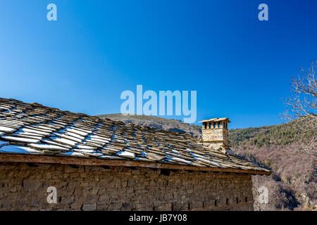 Stone roof, blue sky, snow and chimney Stock Photo