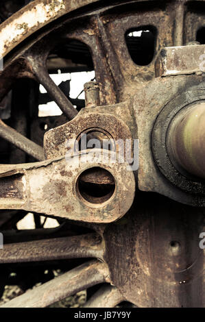 A fragment of an old damaged and rusty steam engine, old style type locomotive, vertical frame. Stock Photo