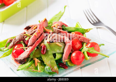 Strips of roast beef on nest of sauteed vegetables Stock Photo