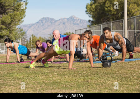 Blond fitness instructor leading push-ups near mountain Stock Photo