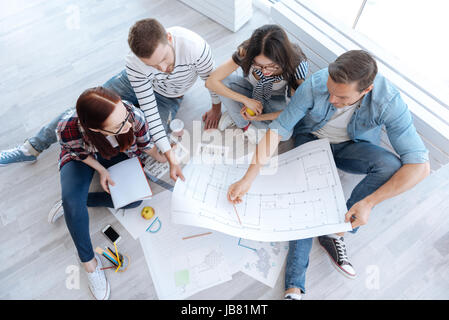 Top view of hard working architects looking at the blueprint Stock Photo