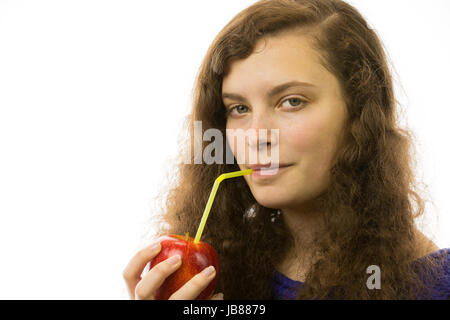 Eine junge hübsche Frau hält einen Apfel mit Strohhalm in der Hand Stock Photo