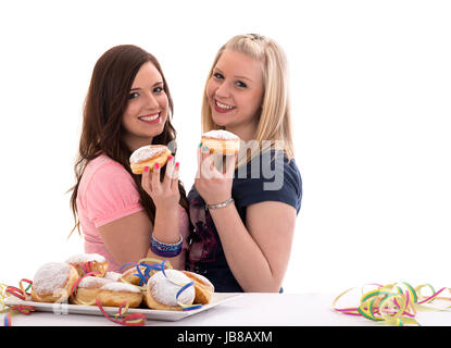 two girls eating carnival doughnuts on a prepared dish Stock Photo