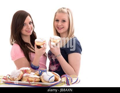 two girls eating carnival doughnuts on a prepared dish Stock Photo
