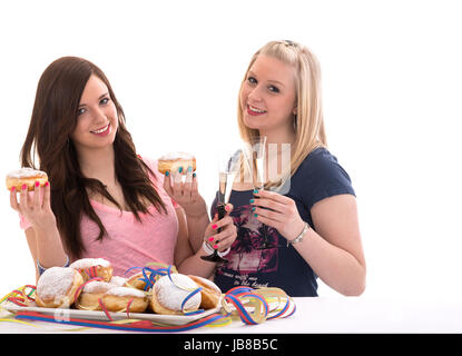 two girls eating carnival doughnuts on a prepared dish Stock Photo