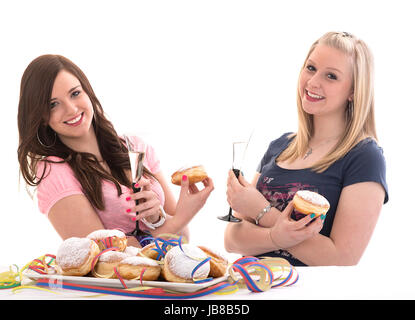 two girls eating carnival doughnuts on a prepared dish Stock Photo