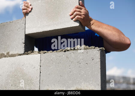 Close up of industrial bricklayer installing bricks on construction site Stock Photo