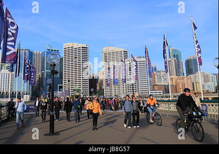 People walk on Pyrmont bridge in Darling Harbour in Sydney Australia. Stock Photo