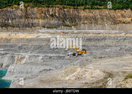 View of the ENCI (First Dutch Cement Industry) quary with dump trucks and a large excavator, mining marl. Maastricht, The Netherlands. Stock Photo
