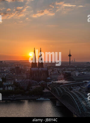 River Rhine at sunset, looking towards Cologne Cathedral (Kölner Dom) with Hohenzollern Bridge (Hohenzollernbrücke) in foreground, Cologne, Germany Stock Photo