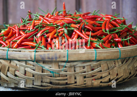 Fresh red chili peppers close up in a basket. Cooking ingredients Stock Photo