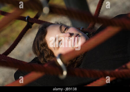 Eine junge hübsche Frau liegt in einem Netz Stock Photo