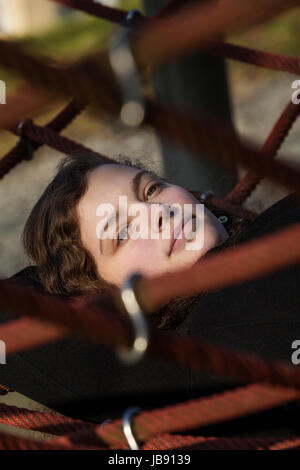 Eine junge hübsche Frau liegt in einem Netz Stock Photo