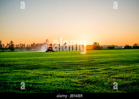 water pump at sunset in a big green field Europe Stock Photo