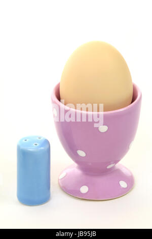 Ausschnitt eines Frühstückstisches mit Ei im Eierbecher und kleinem Salzstreuer Stock Photo