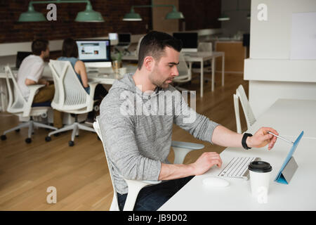 Male executive working on digital tablet in office Stock Photo