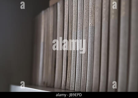 Old books on wooden shelf. No readable labels. Stock Photo