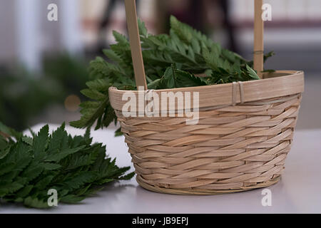 Green leaves of fern in basket. Rustic wedding decoration. Stock Photo