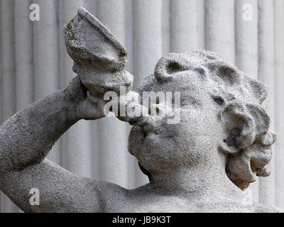 Stone statue of an angel holding a trumpet that blows. Stock Photo