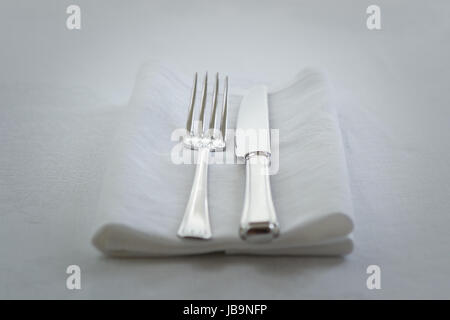 knife and fork on white napkin Stock Photo