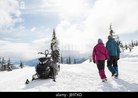 Couple walking together in snowy alps during winter Stock Photo