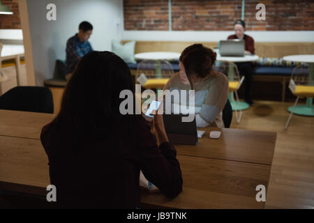 Executive using mobile phone in office Stock Photo