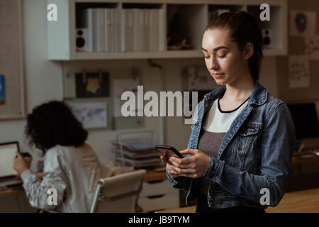 Young female executive using mobile phone in office Stock Photo