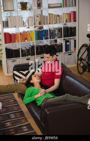 Couple relaxing on sofa in living room at home Stock Photo