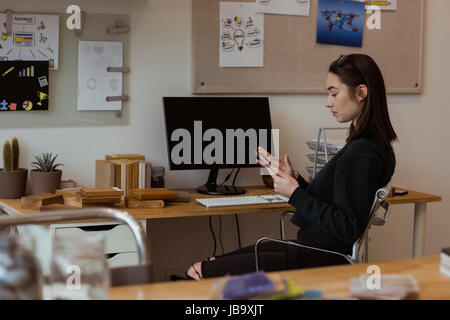 Female executive using digital tablet at desk in office Stock Photo