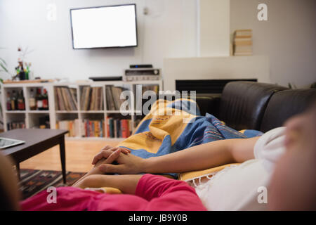 Affectionate couple relaxing on sofa in living room at home Stock Photo