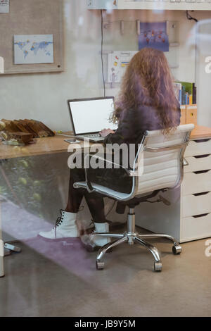 Female executive working on laptop at desk in office Stock Photo
