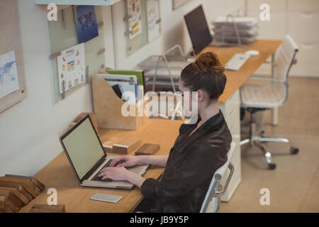 Female executive working on laptop at desk in office Stock Photo