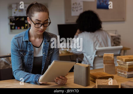 Female executive using digital tablet at desk in office Stock Photo