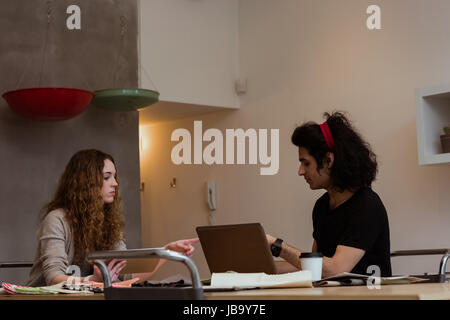 Business colleagues interacting with each other while working together in office Stock Photo