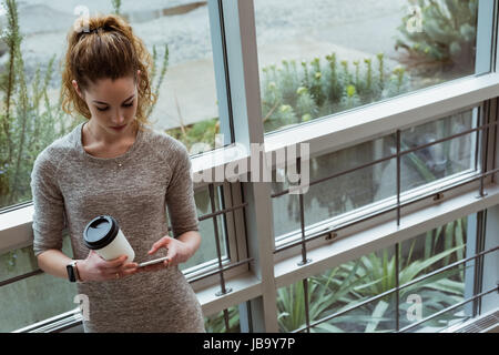 Female executive using mobile phone in office Stock Photo