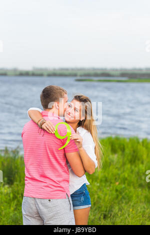 Man and woman holding the number 9 in nature. Concept of numbers, measurement, amount, quantity, accounting and mathematics Stock Photo