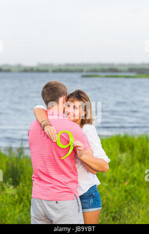 Man and woman holding the number 9 in nature. Concept of numbers, measurement, amount, quantity, accounting and mathematics Stock Photo