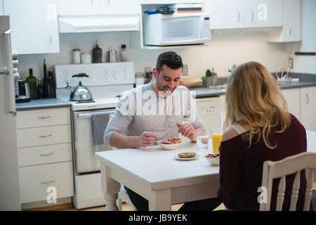 Couple having breakfast in kitchen at home Stock Photo