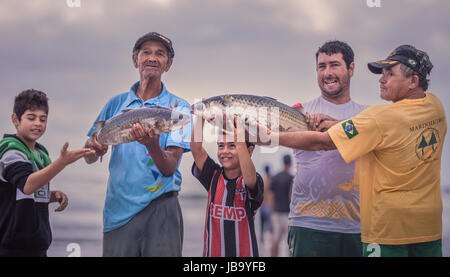 Ilha Do Mel, Paraná, Brazil - June 3, 2017: Native fishermen from Honey Island holding fish for the photo. Stock Photo