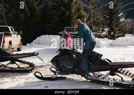 Man riding snowmobile in snowy alps during winter Stock Photo