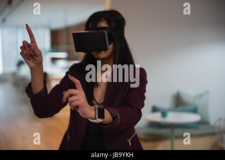 Female executive using virtual reality headset in office Stock Photo